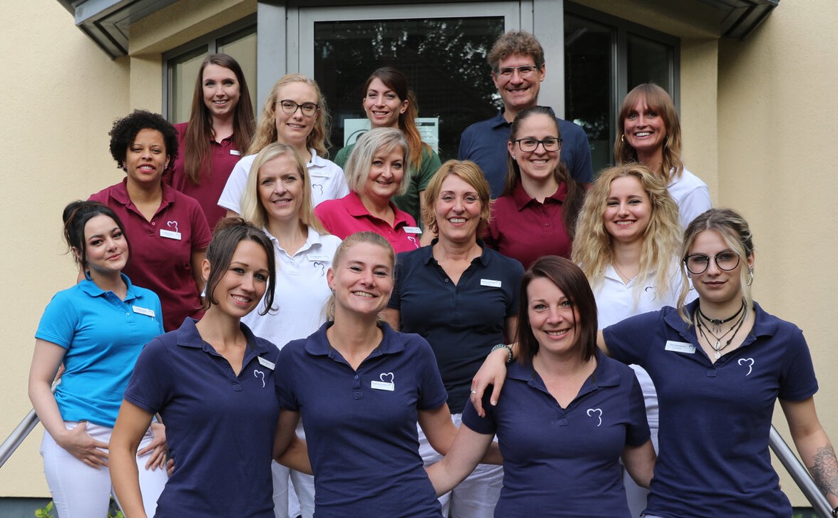 Das Team des dentimedicum Hamburg vor dem Praxiseingang am Kleekamp
